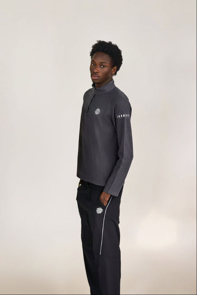 Two models wearing matching tracksuits with a brand logo on a plain background